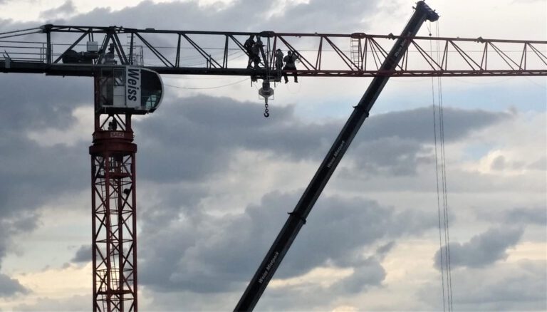 Monteure im Kranausleger bei der Kranmontage Saez Baukran